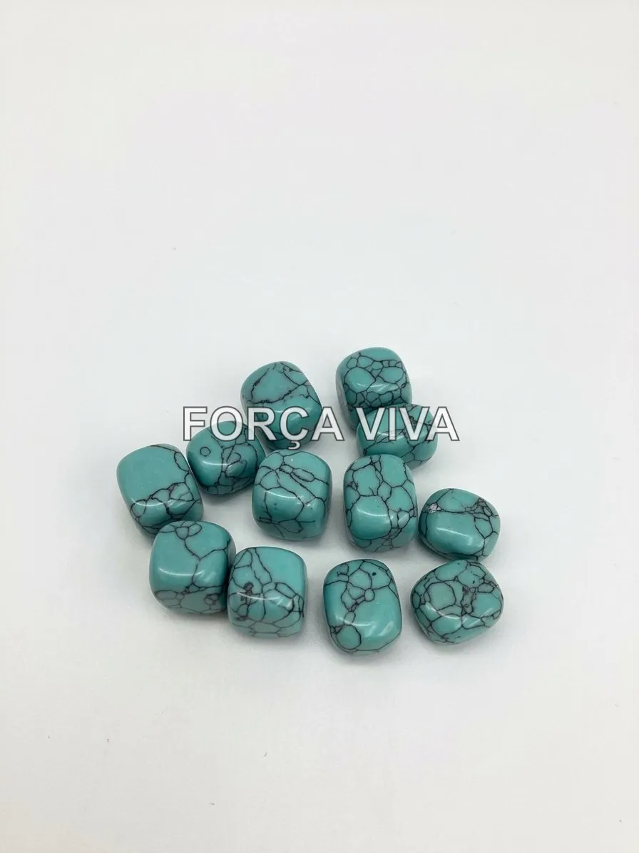 Conjunto de pedras turquesa roladas em tom azul-vívido com veios escuros sobre tecido neutro.